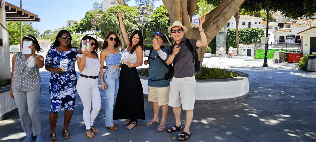 Happy visitors holding up their chocolate bars on Plaza Virgen de la Peña